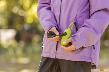 cropped shot of woman holding container with bags for cleaning after pet in park